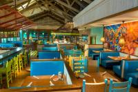 a restaurant with wooden tables and blue chairs at The Coral at Atlantis in Nassau