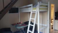 a bunk bed with a ladder and a table in a room at Le Betrot in Estissac