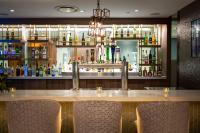 a bar with chairs in front of a counter with alcohol at Holiday Inn Toronto Downtown Centre by IHG in Toronto