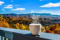 eine Kaffeetasse auf dem Vorsprung eines Balkons in der Unterkunft Barenberg Cabin - Secluded Unobstructed Panoramic Smoky Mountains View with Two Master Suites, Loft Game Room, and Hot Tub in Gatlinburg