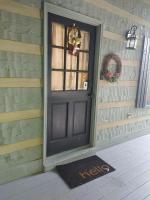 eine Tür mit einer Willkommensmatte vor einem Haus in der Unterkunft Barenberg Cabin - Secluded Unobstructed Panoramic Smoky Mountains View with Two Master Suites, Loft Game Room, and Hot Tub in Gatlinburg