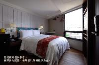 a hotel room with a bed and a window at Reddot Hotel in Taichung
