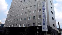 Un edificio con un cartel al costado. en Toyoko Inn Tsushima Izuhara, en Tsushima