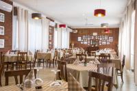 een restaurant met tafels en stoelen en een bakstenen muur bij Locanda La Castellana in Castello d'Agogna