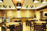 a restaurant with tables and chairs in a room at Hotel Senses in Kolkata