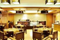 a restaurant with tables and chairs and a kitchen at Hotel Senses in Kolkata