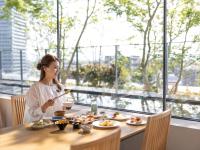 a woman sitting at a table eating food at THE BLOSSOM KUMAMOTO in Kumamoto