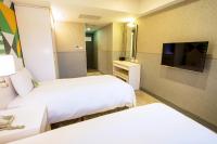 a hotel room with two beds and a flat screen tv at Ximen Citizen Hotel in Taipei