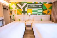 two beds in a room with a love shopping sign on the wall at Ximen Citizen Hotel in Taipei