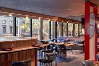 un restaurant avec des tables, des chaises et des fenêtres dans l'établissement Quincy Hotel Melbourne, à Melbourne