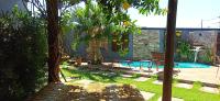 un patio trasero con una piscina con un banco y árboles en Casas Bom Sono, en Foz do Iguaçu