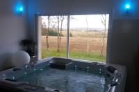 a bath tub in a room with a large window at meublé entier indépendant en contigu de ma maison in Saint-Georges-sur-Moulon