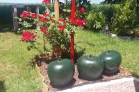 three large green spheres in a garden with red flowers at meublé entier indépendant en contigu de ma maison in Saint-Georges-sur-Moulon