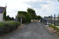 a gravel driveway with a fence and a gate at meublé entier indépendant en contigu de ma maison in Saint-Georges-sur-Moulon