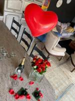 a table with a heart shaped balloon and red roses at Gite wellness Au champ du bouillon proche de Pairi Daiza et de la ville Ath 