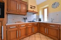 a kitchen with wooden cabinets and a sink at S&#39;Harzala Jaune in Bergheim