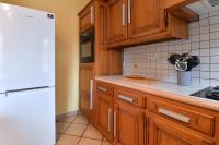 a kitchen with wooden cabinets and a white refrigerator at S&#39;Harzala Jaune in Bergheim