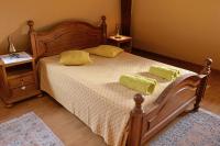 a bedroom with a wooden bed with two pillows on it at S&#39;Harzala Jaune in Bergheim