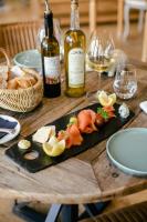ein Holztisch mit Weinflaschen und einem Teller Essen in der Unterkunft Le Manoir des Impressionnistes - Bord de Mer in Honfleur