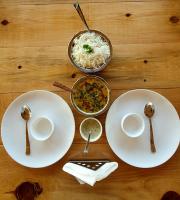 uma mesa com pratos de comida e uma tigela de arroz em The Tiger Claw Resort em Rāmnagar