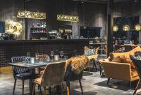 un ristorante con tavoli e sedie e un bar di Aurora Queen Resort Igloos a Saariselka