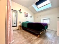 a bedroom with a bed and a skylight at Le Repaire du p&#39;tit Chartreux by LPNL in Rives