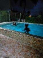two dogs playing in a swimming pool at night at Gîtes La Troisième Chute in Capesterre-Belle-Eau