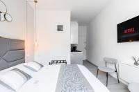 a white bedroom with a bed and a tv at Studio inspiration hôtel standing Vieux-Port in Marseille