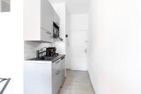 a white kitchen with white cabinets and a sink at Studio inspiration hôtel standing Vieux-Port in Marseille