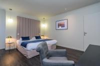 a hotel room with a bed and a chair at Saint Georges Hotel &amp; Spa in Chalon-sur-Saône