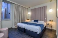 a hotel room with a large bed and a window at Saint Georges Hotel &amp; Spa in Chalon-sur-Saône