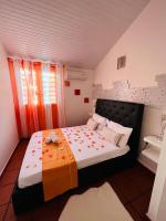 a bedroom with a bed with an orange and white blanket at Villa Paradis in Le François