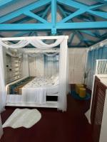 a bedroom with a white canopy bed in a room at Villa Paradis in Le François