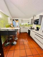 a kitchen with an orange tile floor and white cabinets at Villa Paradis in Le François