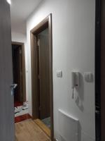 a bathroom with a mirror and a door to a room at Twins Apartments in Čačak