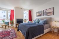 1 dormitorio con cama, TV y cortinas rojas en Stilvolles Studio in downtown Mitte, Boxspringbett, Balkon, Blick über Berlin auf den Himmel, zentrale Lage, Kiez vor der Haustür, en Berlín