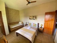 a bedroom with a bed and a couch in it at Chico de Sá Pousada in Pirenópolis