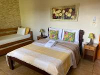 a bedroom with a bed with pillows on it at Chico de Sá Pousada in Pirenópolis