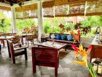 a restaurant with tables and chairs and plants at The Dream Beach Resort in Taytay