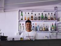 ein Mann steht vor einem Regal mit Flaschen in der Unterkunft O3 Beach Resort in Palolem