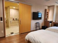 a hotel room with a bed and a sliding glass door at Kindness Hotel - Kaohsiung Main Station in Kaohsiung
