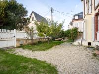 a yard with a white fence and a tree at Apartment Le Chalet by Interhome in Cabourg