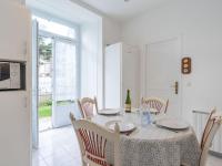 a dining room with a table and chairs and a kitchen at Apartment Le Chalet by Interhome in Cabourg