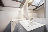 a white bathroom with a sink and a mirror at Large studio with balcony at the heart of Biarritz - Welkeys in Biarritz