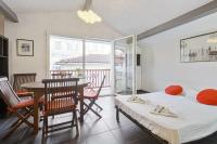 a room with two beds and a table and chairs at Large studio with balcony at the heart of Biarritz - Welkeys in Biarritz