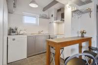 a kitchen with a table and a counter top at Large studio with balcony at the heart of Biarritz - Welkeys in Biarritz