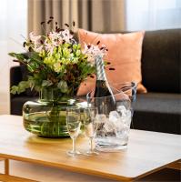 a bottle of champagne and glasses on a table with flowers at Hotel Sparre in Porvoo