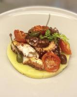 Un plato de comida con carne y verduras encima. en Sasaràl Suites, en Cesena