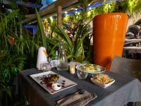 Una mesa con platos de comida y plantas. en Hotel Ker Alberte, en Cayenne