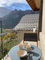 a blue table with two cups on a balcony with mountains at Appartement Le Lauzet in La Roche-de-Rame